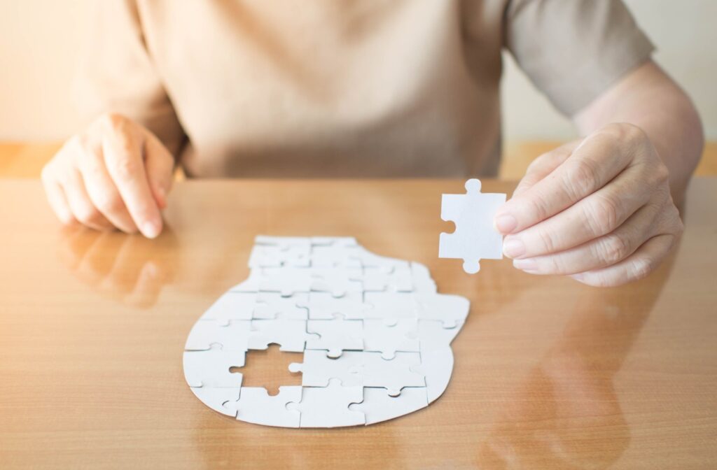 a person is holding the missing puzzle piece of a puzzle resembling the human mind.